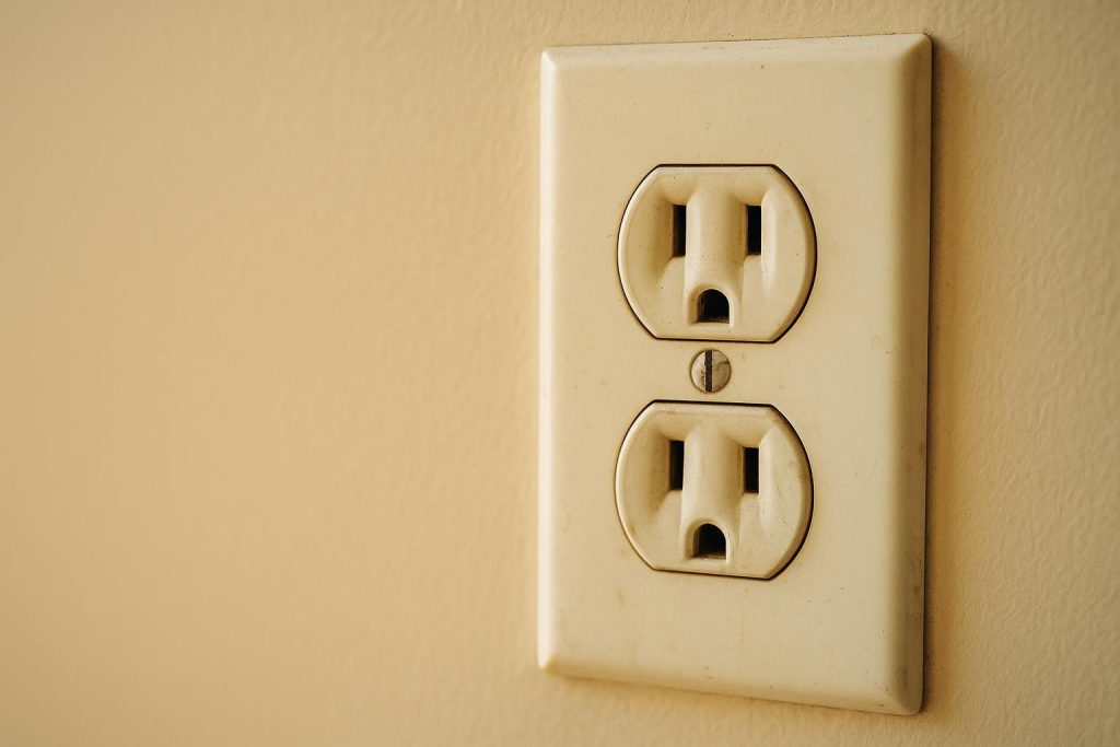 Close-up of a household outlet that might buzz from power lines, hinting at a fire hazard